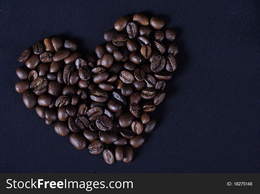 Heart from the fried grains of coffee on a black background. Heart from the fried grains of coffee on a black background