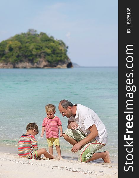 Father and two children playing on beach. Father and two children playing on beach