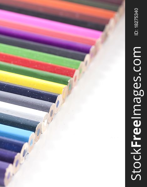 A standard diagonal row of colorfull colored pencils on white and a small depth of field