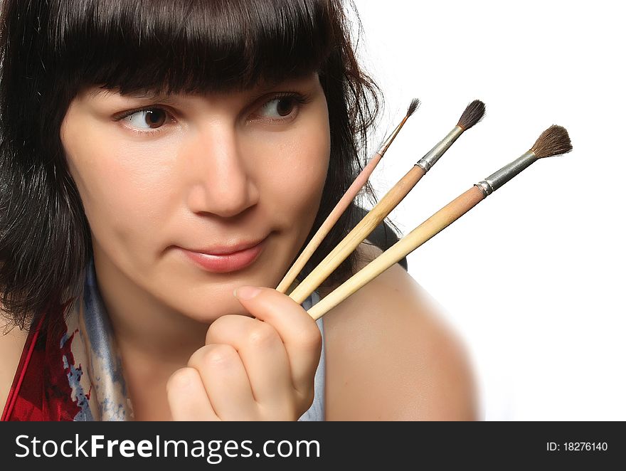 Beautiful girl holding brushes and smiling on a white background. Beautiful girl holding brushes and smiling on a white background.