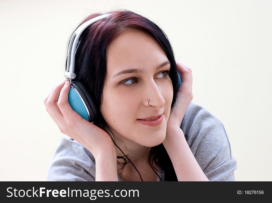 Caucasian dark haired woman with earphones on the chair