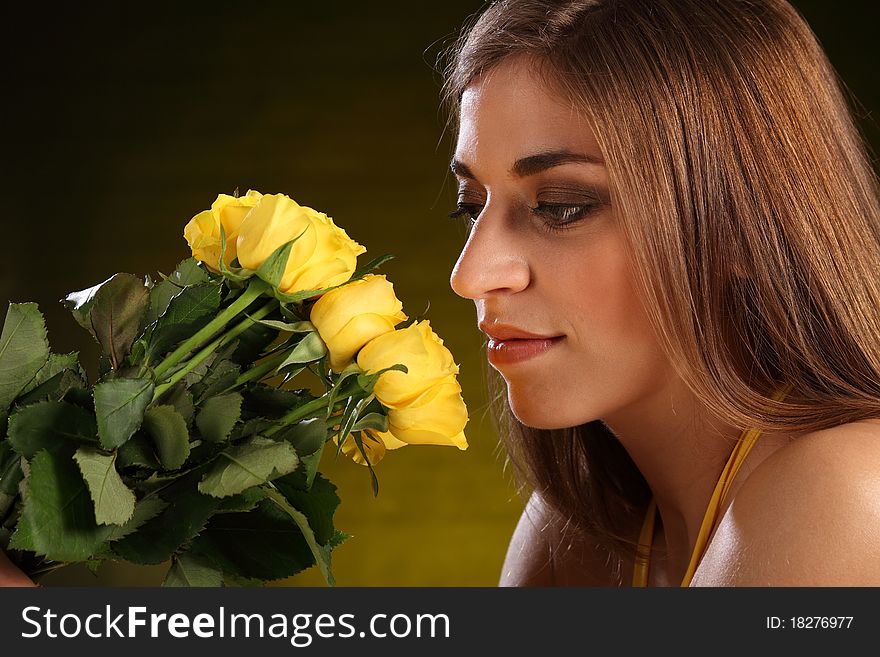Headshot of beautiful young caucasion woman holding bunch of yellow roses to her face. Headshot of beautiful young caucasion woman holding bunch of yellow roses to her face.