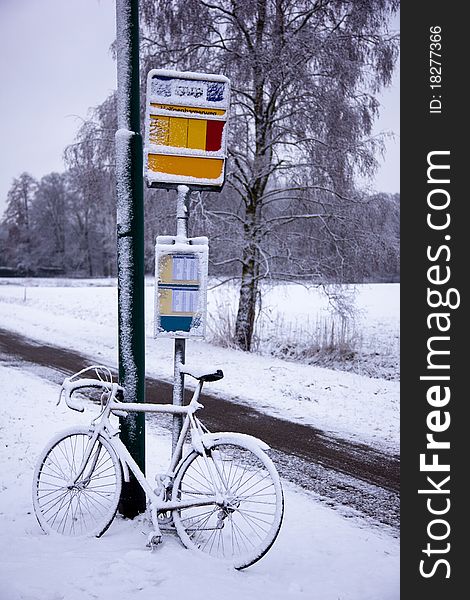 A bike in the snow by the busstop