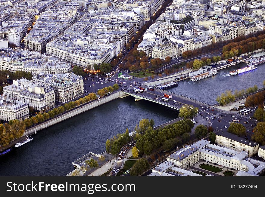 A bird's-eye view of a bridge across the Seine river with the streets and buildings on its both sides.