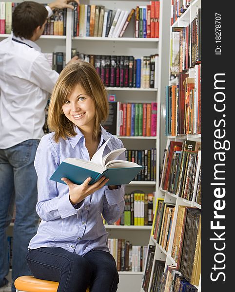 Young beautiful woman reading book in the library. Young beautiful woman reading book in the library