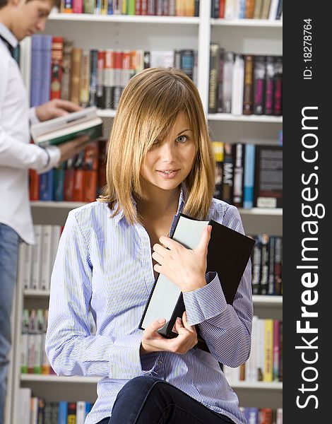 Young woman in the library with the book