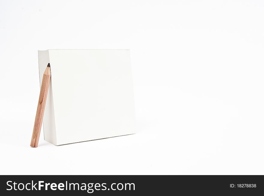 An isolated empty notepad standing vertically with a pencil leaning on it. An isolated empty notepad standing vertically with a pencil leaning on it.