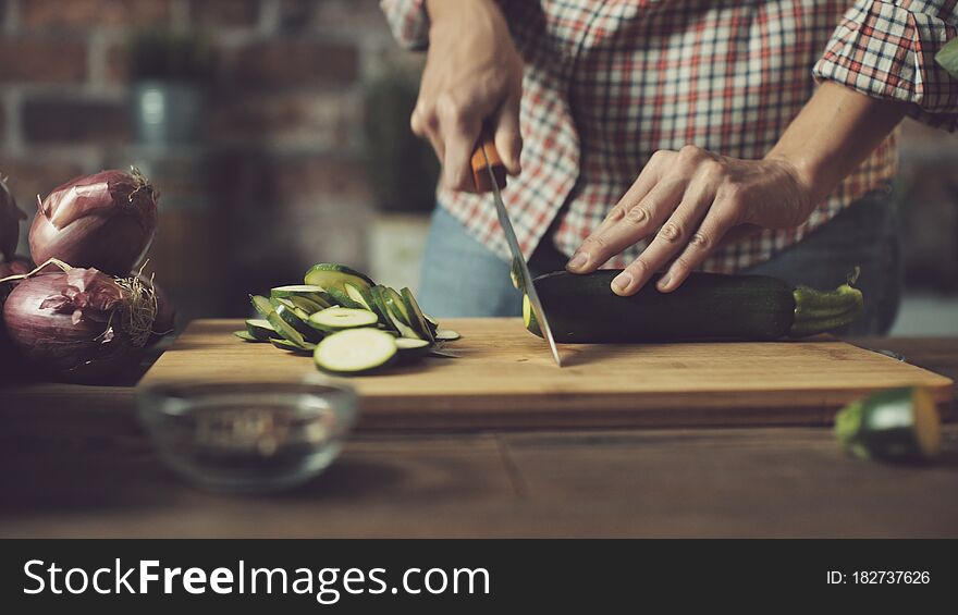 Woman preparing a healthy vegan meal, she is slicing fresh vegetables on a chopping board, nutrition and lifestyle concept. Woman preparing a healthy vegan meal, she is slicing fresh vegetables on a chopping board, nutrition and lifestyle concept