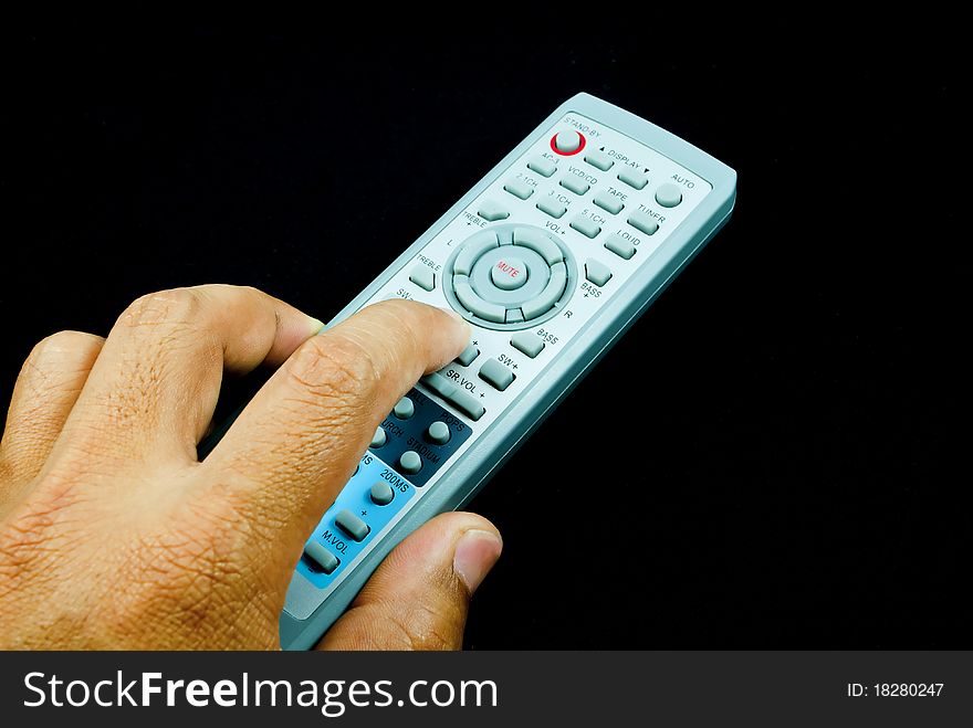 Remote control in hand, isolated on black
