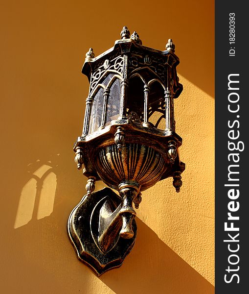 Decorative electric lamp against the yellow concrete wall. Decorative electric lamp against the yellow concrete wall