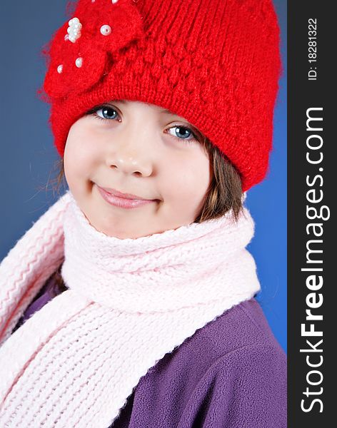 Girl in winter clothes on blue background