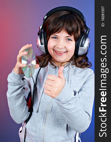 Cute little girl with earphones and cd isolated on blue