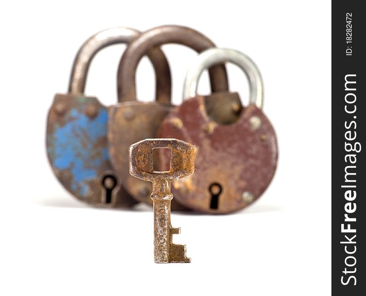 Rusty old key with blurred three locks in the back, white background. Rusty old key with blurred three locks in the back, white background