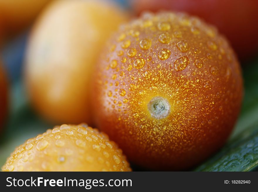 A close up shot of Red Tomato with Yellow Spots and droplets of water.