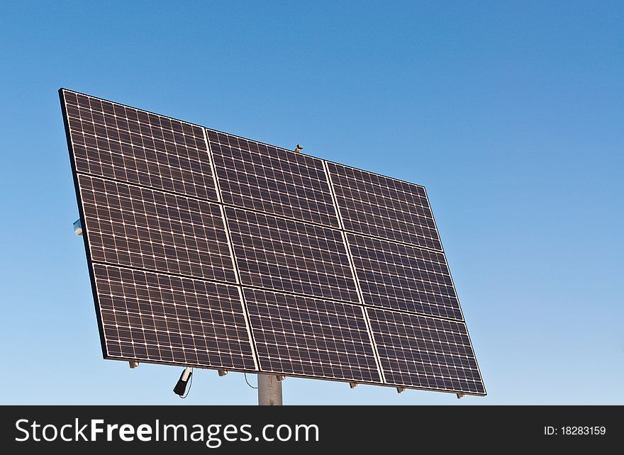 Photovoltaic solar panel array with a clear blue sky in the background. Photovoltaic solar panel array with a clear blue sky in the background.