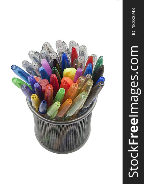 Colored pens in the pen holder, isolated on white background. Focus is on the tips of the pens.