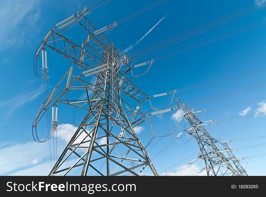 A line of electrical transmission towers carrying high voltage lines. A line of electrical transmission towers carrying high voltage lines.