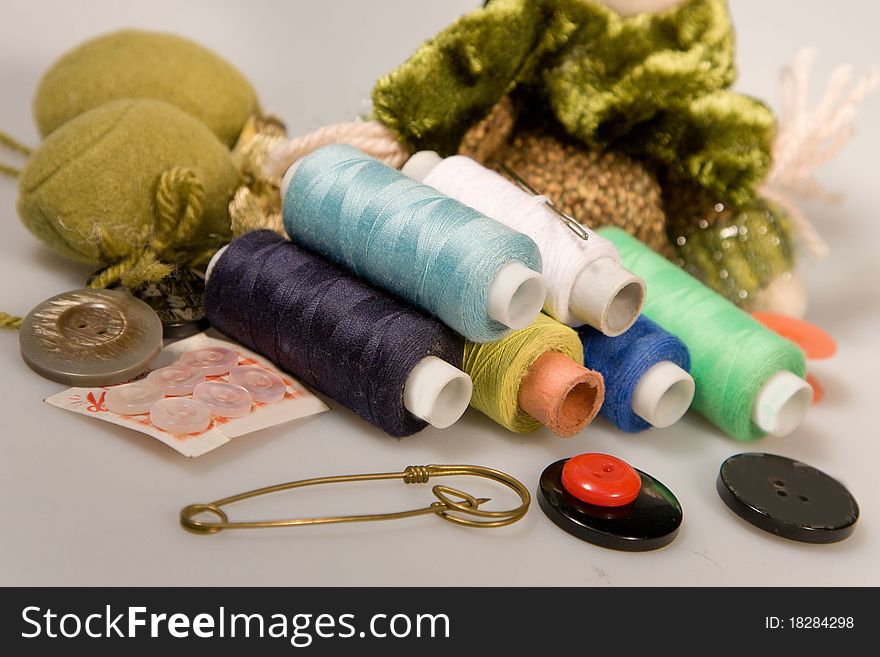 Thread sewing and needles with buttons on a white background