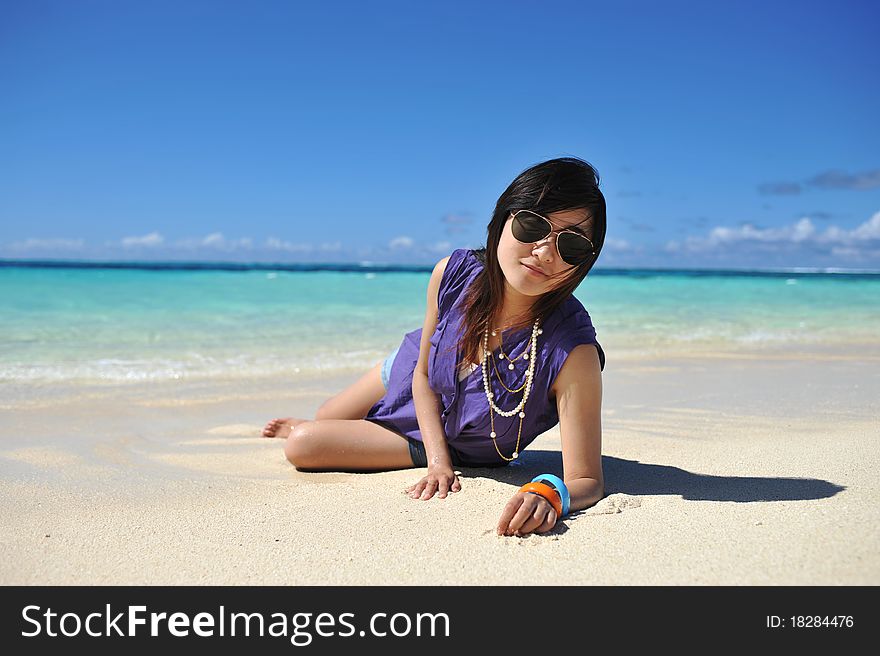 Asian Girl crouch on the sands beach of Saipan Island