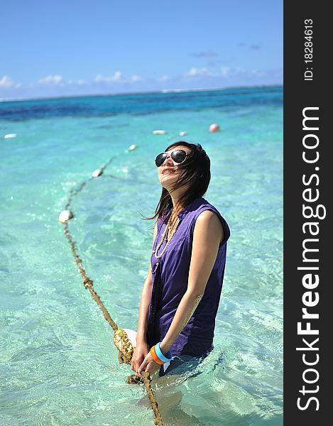 Asian Girl on the beach of Saipan Island,playing in the sea water with the strings. Asian Girl on the beach of Saipan Island,playing in the sea water with the strings.