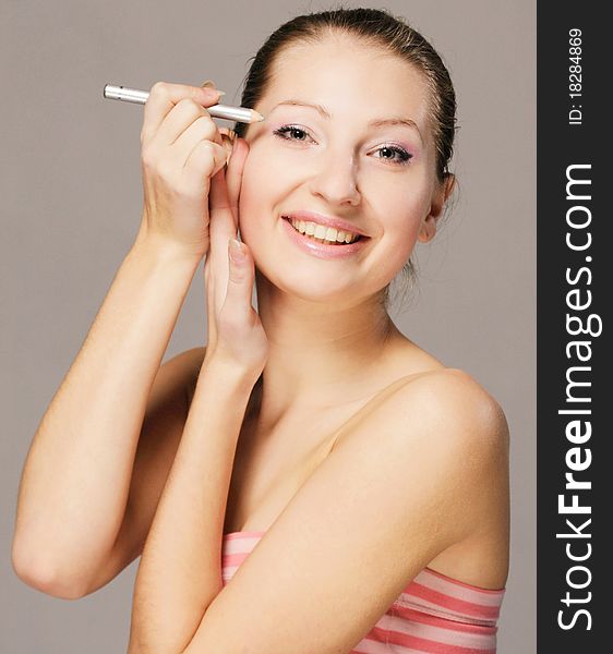 A young smiling girl with a pencil make-up