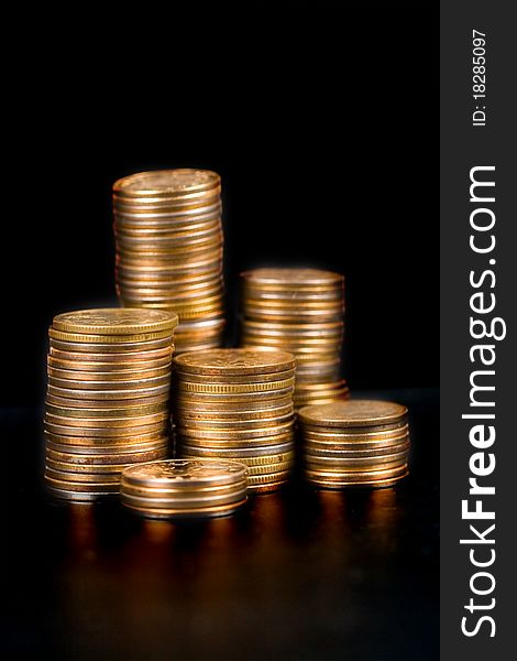 Piles of gold coins on a black background