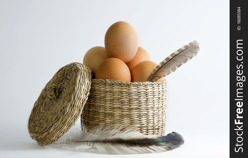 Eggs in basket with feathers