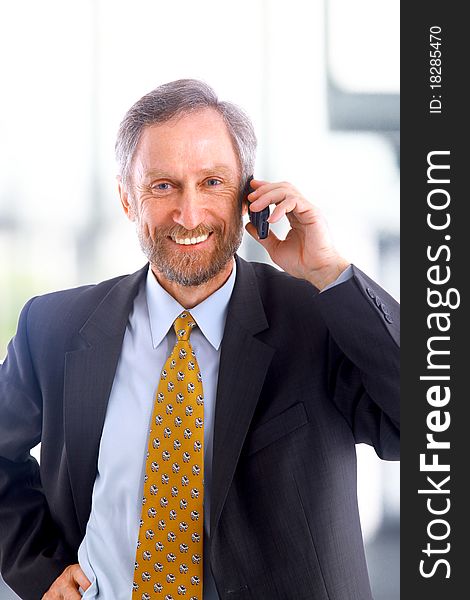 Closeup portrait of a handsome mature business man speaking on mobile phone