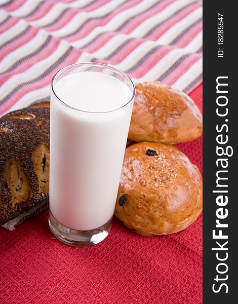 Fresh bread with glass of milk on a red background