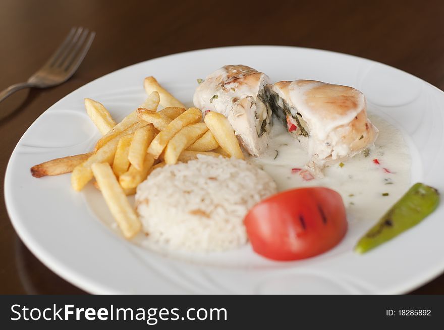 Photo of chicken Wrap meal with chips, tomato pepper and rice.