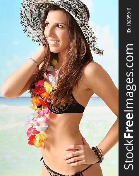 Young and beautiful brunette girl wearing a bikini and a sun hat at the beach. Young and beautiful brunette girl wearing a bikini and a sun hat at the beach