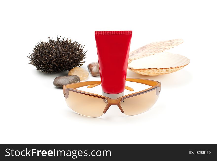 Sun glass on white background with seashell,stones, sea-urchin and sun block. Sun glass on white background with seashell,stones, sea-urchin and sun block