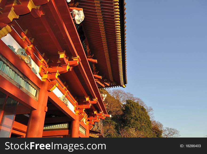 An upward shot of a Japanese temple with red pillars and roof, taken in the late afternoon. An upward shot of a Japanese temple with red pillars and roof, taken in the late afternoon.