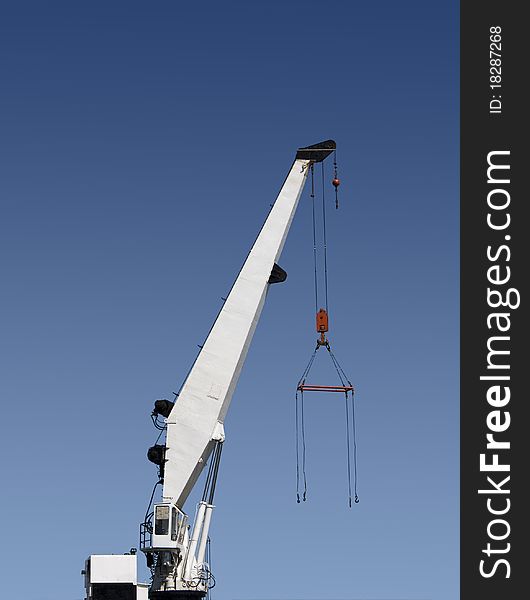 Cargo ship crane against blue sky