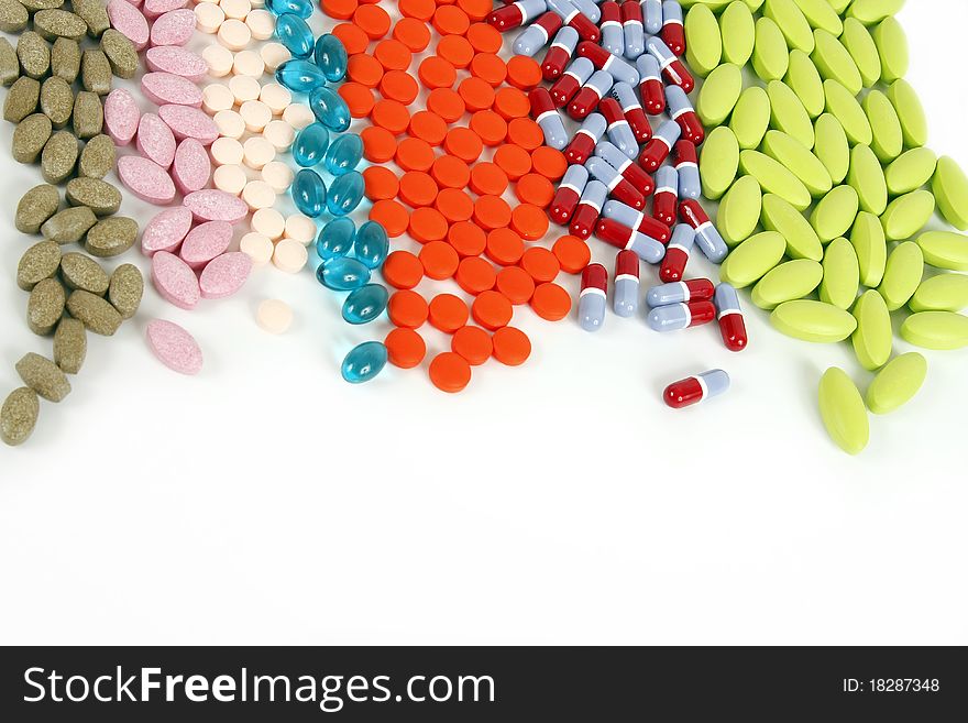 Many different pills lined up on a white background. Many different pills lined up on a white background.