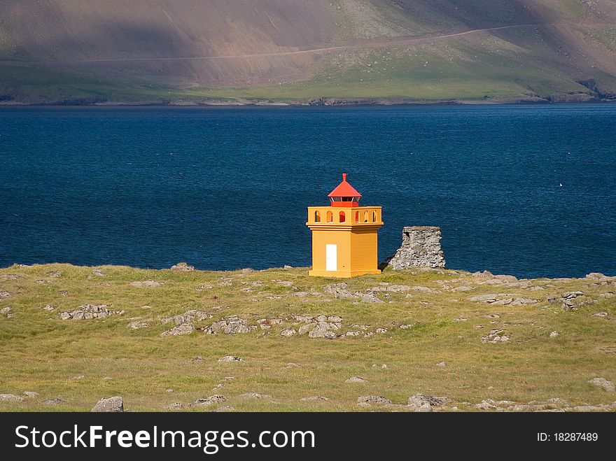 Lighthouse Faskrudsfjordur yellow in the fjord in Iceland