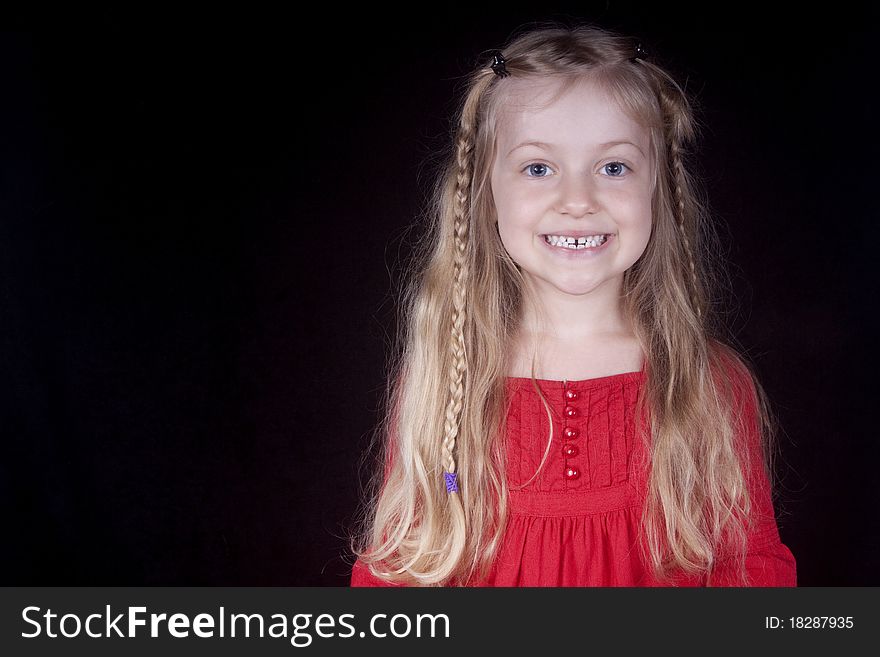 A little blond girl in red smiling. A little blond girl in red smiling