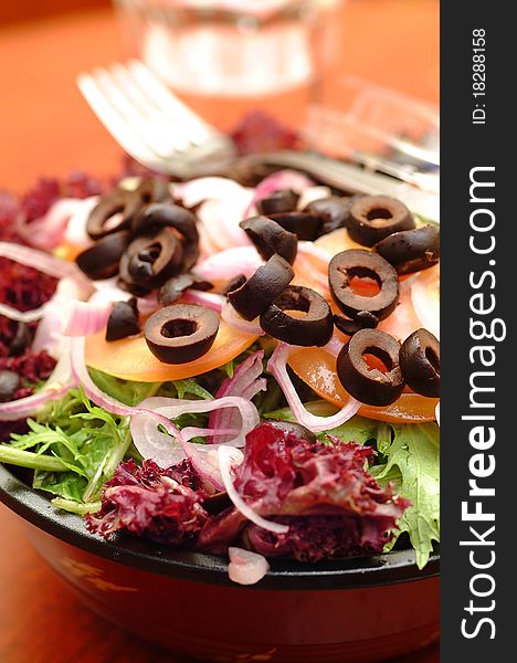 Salad with fresh lettuce leaves, tomato,feta, olives, pepper.