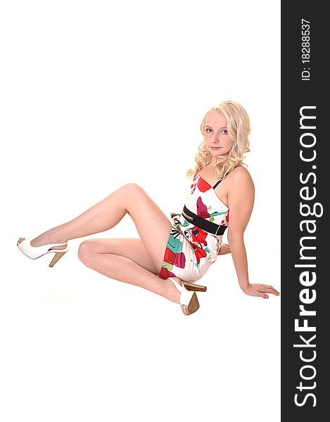 A pretty teenager with long blond hair sitting on the floor, wearing a colorful dress, for white background. A pretty teenager with long blond hair sitting on the floor, wearing a colorful dress, for white background.