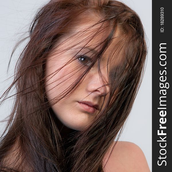 A close-up shot of a beautiful woman whose hair is blowing in front of her face, making eye contact with the viewer. A close-up shot of a beautiful woman whose hair is blowing in front of her face, making eye contact with the viewer.