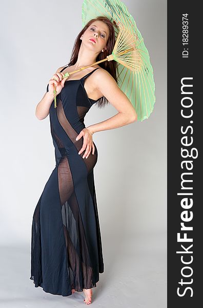 A portrait of a beautiful young woman wearing a racy dress and holding a green parasol. A portrait of a beautiful young woman wearing a racy dress and holding a green parasol.