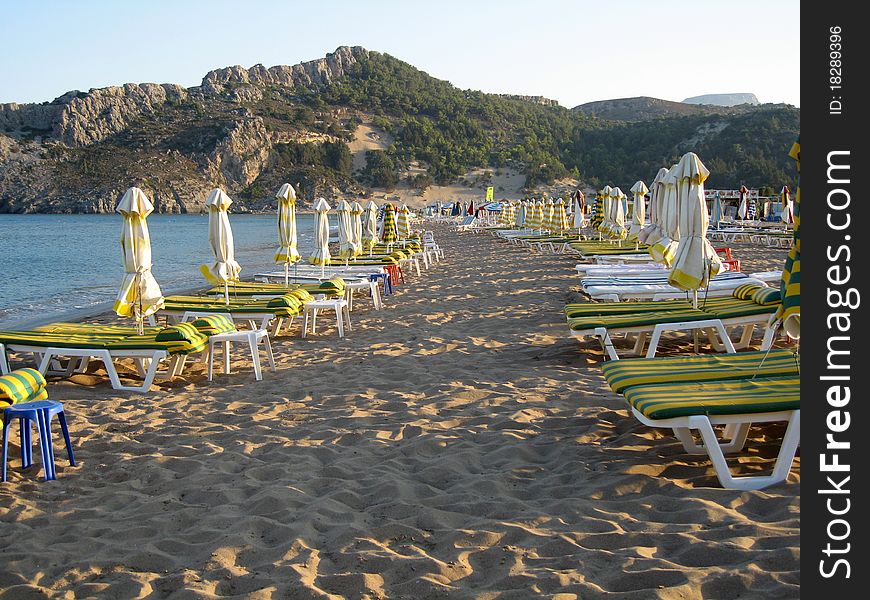 Beach with sun loungers and umbrellas near the blue sea. Beach with sun loungers and umbrellas near the blue sea