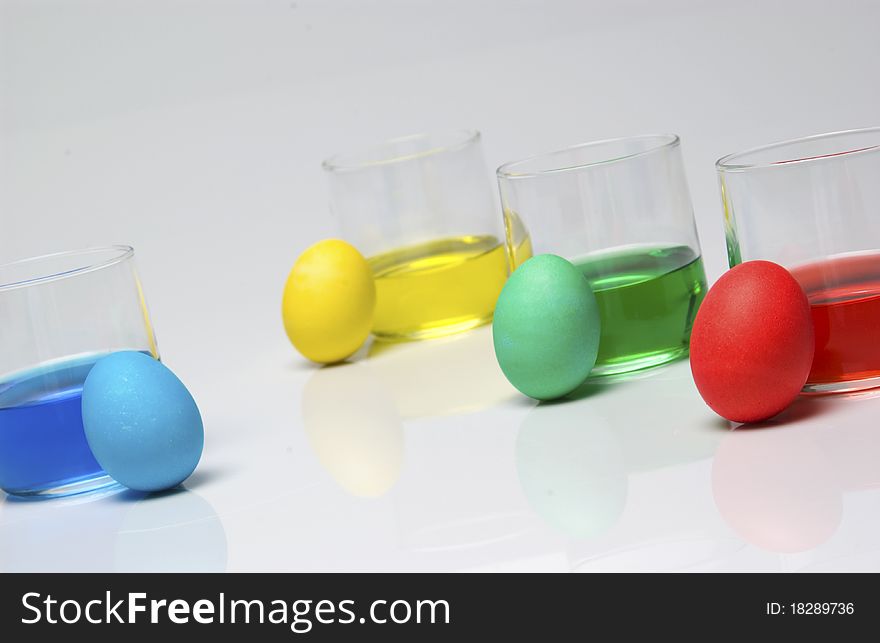 Blue, yellow, green and red dye with Easter eggs. Blue, yellow, green and red dye with Easter eggs