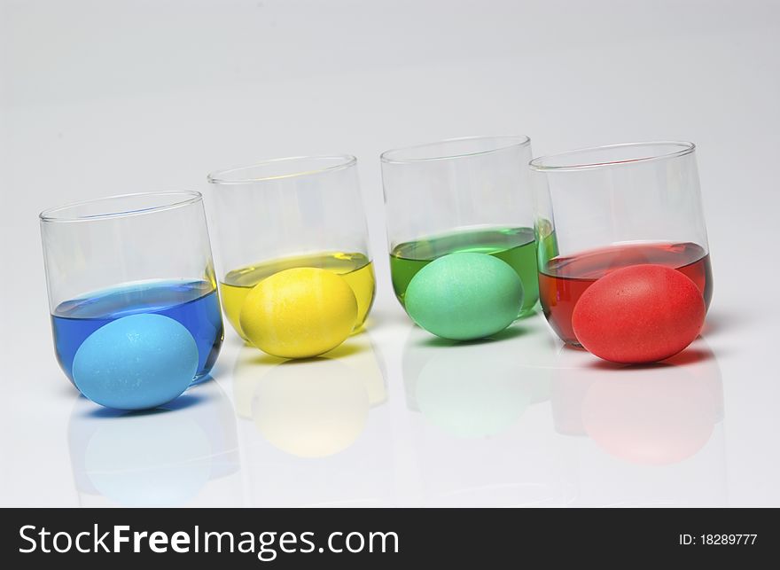 Blue, yellow, green and red dye with Easter eggs. Blue, yellow, green and red dye with Easter eggs