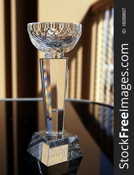Glass winning cup on the black table in sunlight