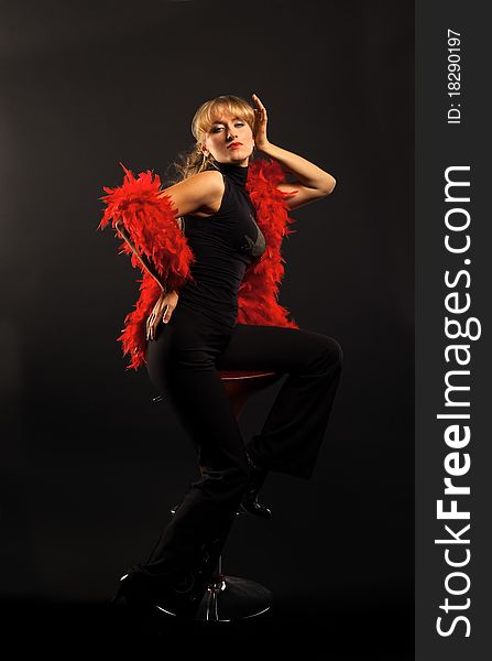 Blond woman dance with red boa in dark