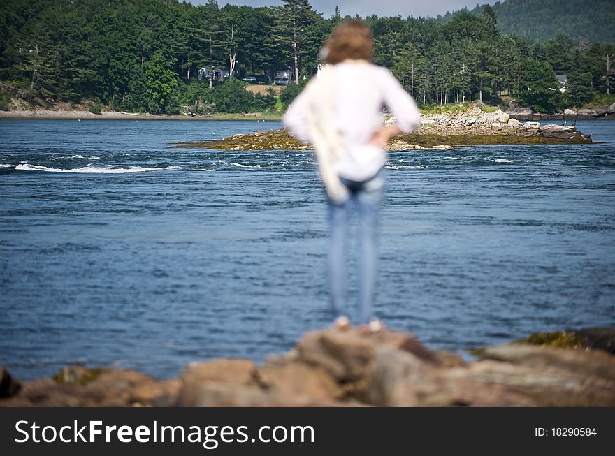 A woman looks out onto a cove in Down East Maine. A woman looks out onto a cove in Down East Maine.