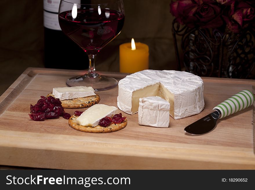 Cheese on wooden board with crackers a glass of redwine. Cheese on wooden board with crackers a glass of redwine