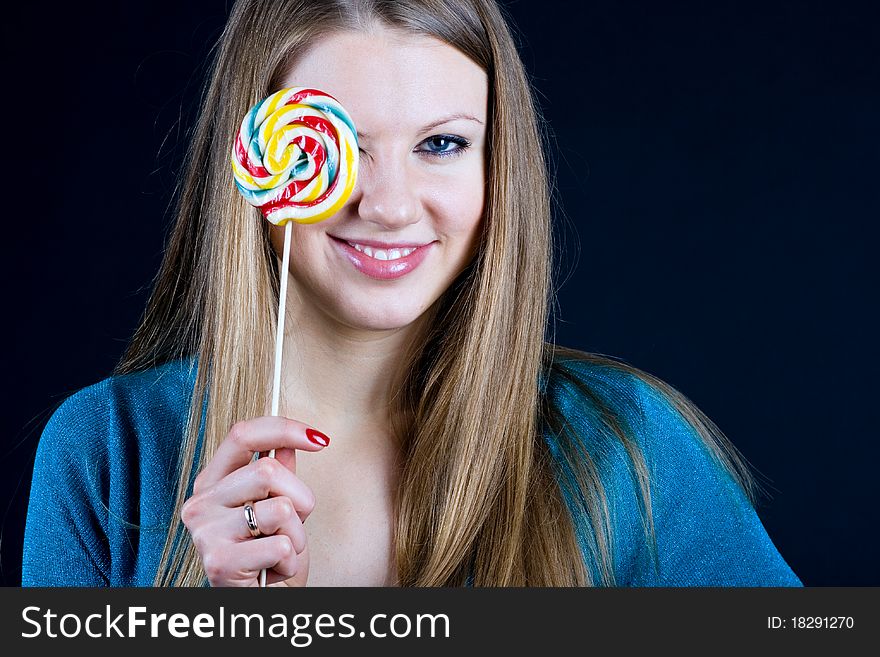 Beautiful girl holding a candy on a stick in his hand