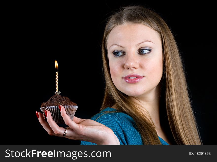 Beautiful girl holding a celebratory muffin with a candle